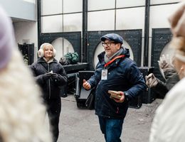 Zu sehen ist der Stadtführer und Gäste, die gerade an der Führung teilnehmen. Sie stehen im Hinterhof von einer Bäckereri.