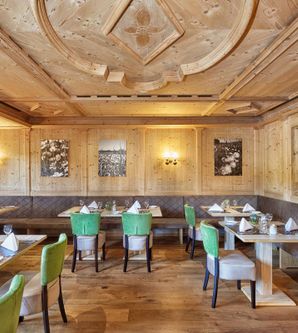 Ein gemütliches Restaurant mit Holzverkleidung und eleganter Einrichtung. Tische sind ordentlich gedeckt und bieten eine einladende Atmosphäre.
