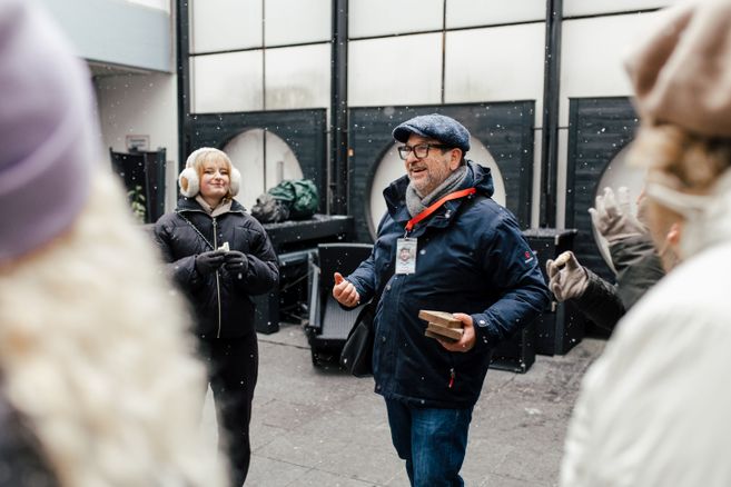 Zu sehen ist der Stadtführer und Gäste, die gerade an der Führung teilnehmen. Sie stehen im Hinterhof von einer Bäckereri.