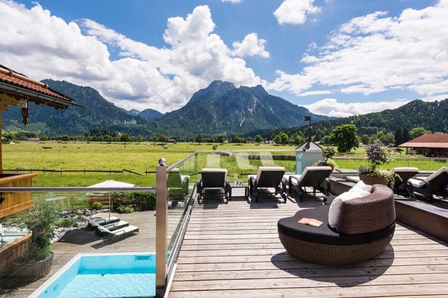 Eine gemütliche Terrasse mit Blick auf die Berge und das grüne Tal. Entspannte Liegen und ein kleiner Pool sorgen für eine einladende Atmosphäre.