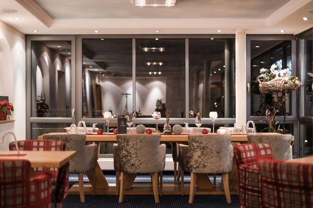 Ein stilvolles Restaurant mit eleganten Stühlen und einem großen Tisch. Die Atmosphäre ist gemütlich und einladend, ideal für gesellige Zusammenkünfte.