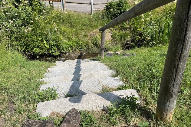 Eine Steintreppe führt hinunter zu einem kleinen Naturkneippbecken.