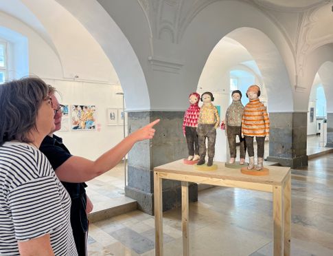 Personen berachten eine Skulptur im Rahmen einer Kunstausstellung